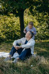 Adult father and little daughter are walking in the park