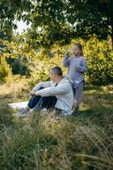Adult father and little daughter are walking in the park