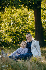 Adult father and little daughter are walking in the park