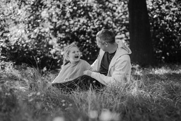Adult father and little daughter are walking in the park