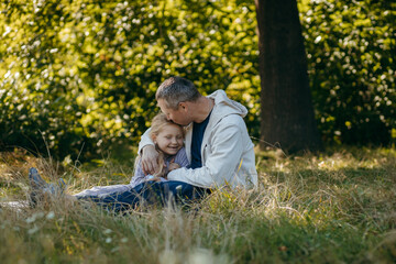 Adult father and little daughter are walking in the park