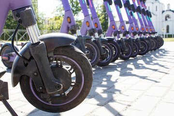 rental electric scooters in parking lot in city
