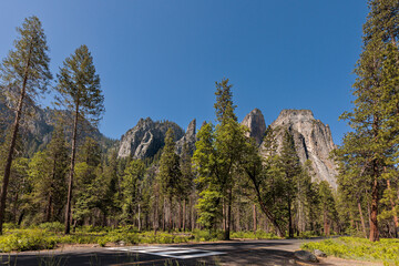 Cathedral Rocks in Yosemite National Park tower above a pedestrian crossing on Southside Drive near...