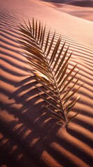 A golden palm leaf rests gracefully on the rippled surface of warm desert sand, casting intricate shadows.