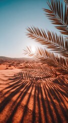 Palm fronds cast dramatic shadows across the warm desert sand at sunrise, creating a serene and tranquil scene.