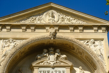 theater facade featuring ornate architectural details such as sculpted figures, decorative reliefs, and columns in Avignon, France