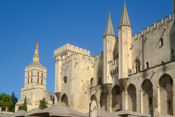 Palais des Papes (Palace of the Popes) in Avignon, France and a gilded statue of the Virgin Mary...