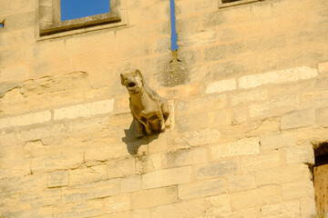 Gothic-style stone tower with a crenellated top and battlements with carved gargoyles in Avignon, France 