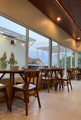 Modern Minimalist Cafe Interior with Wooden Chairs and Large Windows