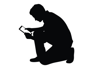 Silhouette of a person kneeling and using a tablet computer