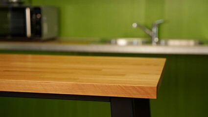 Close up of a wooden countertop in a modern kitchen with green walls