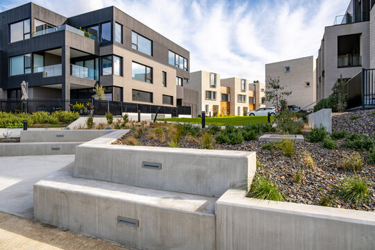 "Modern residential apartment building complex with landscaped outdoor spaces and concrete seating in the communal courtyard garden in Australia. Concept of housing, contemporary architecture
