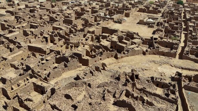 Aerial drone view of the ancient stone houses and ruins of Ouadane in Mauritania, UNESCO World Heritage site showing historic desert architecture and culture