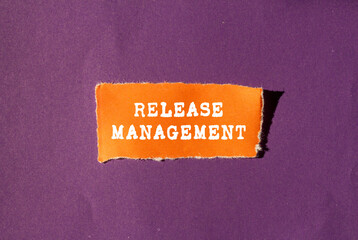 Release Management message written on ripped torn orange paper piece on purple background....