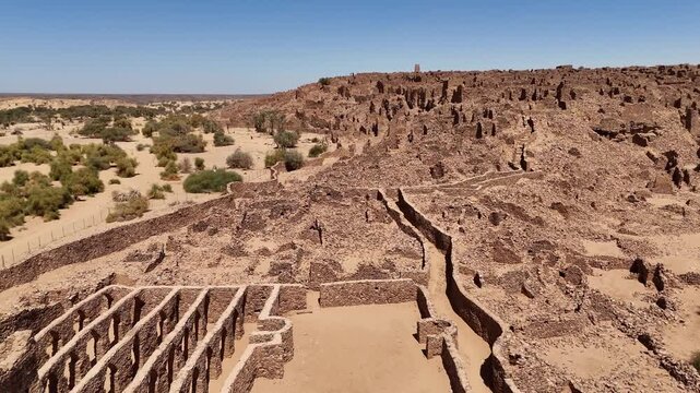 Aerial drone view of the ancient ruins of Ouadane in Mauritania, UNESCO World Heritage site in the Sahara desert with stone architecture and desert landscape