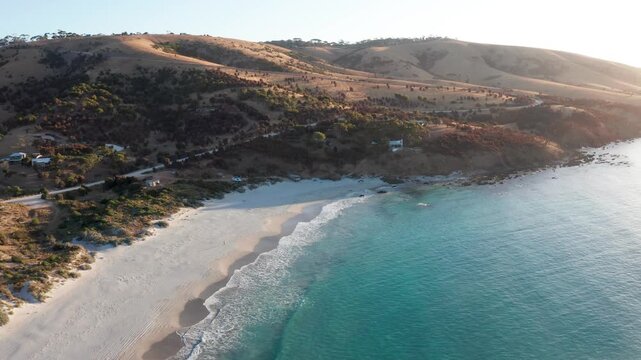 Reverse aerial view of white sand beach with golden hour light, Snelling Beach, Kangaroo Island, South Australia