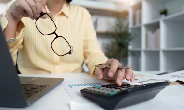 Financial Analysis. Professional accountant reviewing reports with calculator and laptop. - Powered by Adobe