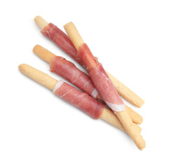 Delicious grissini sticks with prosciutto isolated on white, top view