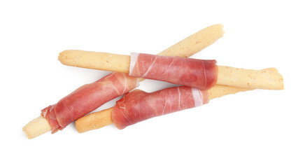 Delicious grissini sticks with prosciutto isolated on white, top view