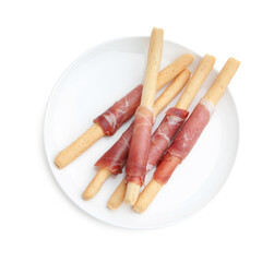 Delicious grissini sticks with prosciutto isolated on white, top view