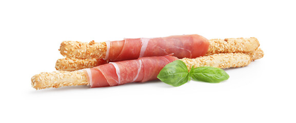 Delicious grissini sticks with sesame seeds, prosciutto and basil isolated on white