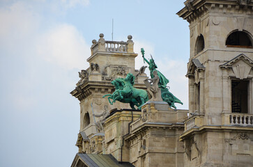 Detail view of bronze horseman statue on the rooftop of a historic building in Budapest, Hungary