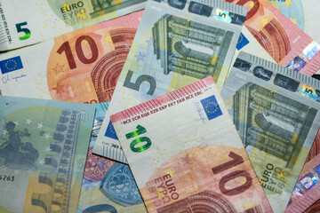 Close up of euro banknotes background. Pile of euro paper money in different denominations. European currency texture for finance, banking, economy, inflation