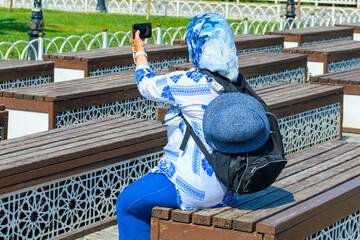A Muslim woman films online videos on her phone or smartphone for her blog and social media. The concept of photography and video blogging while travel.