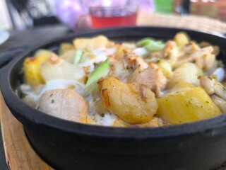 baked potatoes with chicken pieces and herbs in a frying pan