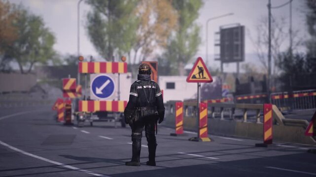 A worker stands in the roadway, directing traffic away from ongoing construction. Brightly colored signs indicate detours and active work areas. Its a clear day in an urban setting.