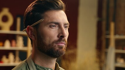 Headshot contemplating thoughtful serious Caucasian man male guy businessman small business owner seller potter ceramist artist think idea touching beard chin doubt deep thoughts indoors pottery shop