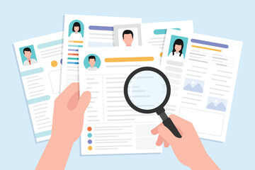 Hand holding magnifying glass for search and finding on a many CV resume paper sheet.