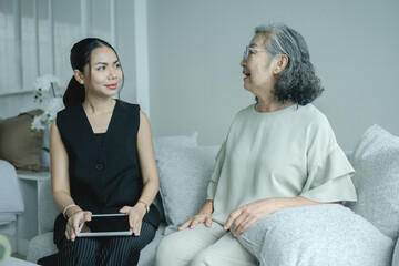 Fototapeta premium Real estate agent consulting elderly customer inside modern home details on digital tablet symbolizing property advice, housing investment or home purchase decisions and supportive customer care.