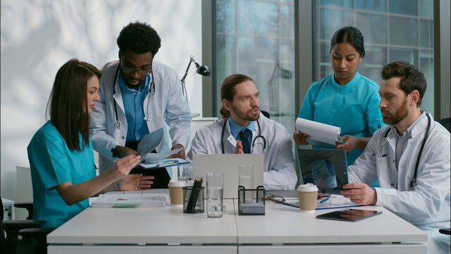 Group multiethnic doctors thinking discussion meeting diverse women men doc specialists medical students surgery planning brainstorm talking speaking disease analyzing health x-ray at hospital clinic