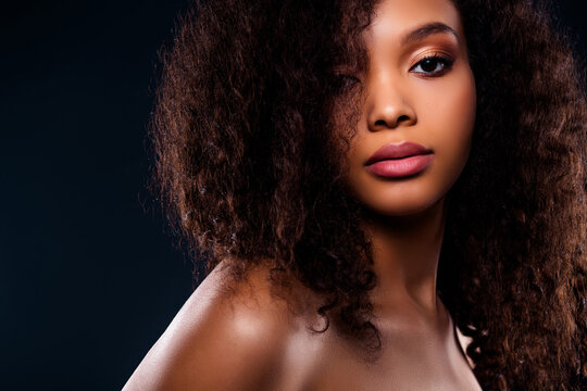 Portrait of a young woman with curly hair and flawless makeup, showcasing natural beauty and confidence