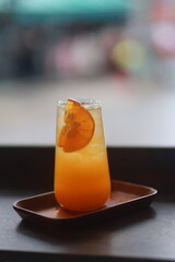 glass of orange juice garnished with two sliced ​​oranges
