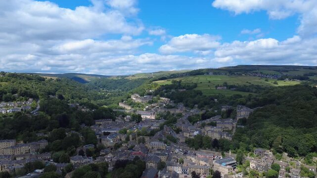 scenic aerial view of the town of hebden bridge in summer sunshine surrounded by fields and hills