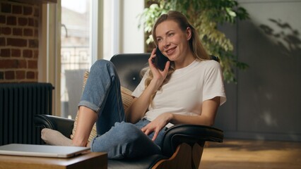 Fototapeta premium Happy Caucasian business woman answering mobile phone call joyful girl talk businesswoman female speaking smartphone calling chatting discussion online conversation work conversation sitting at home