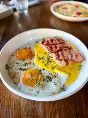 Fried eggs with toast and bacon served on plate