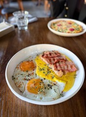 Fried eggs with toast and bacon served on plate