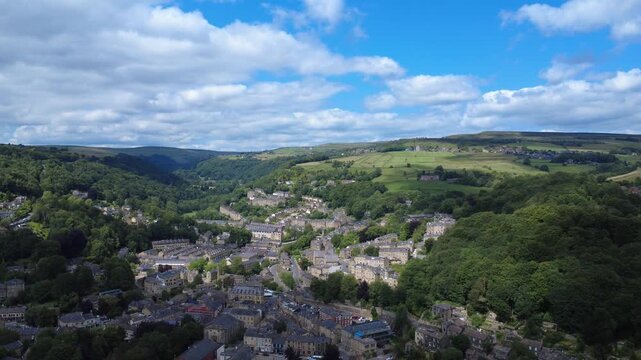scenic aerial view of the town of hebden bridge in summer sunshine surrounded by fields and hills