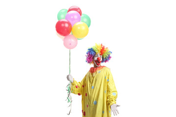 Clown in yellow costume holding balloons