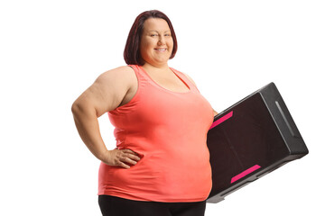 Corpulent woman holding a step aerobic platform