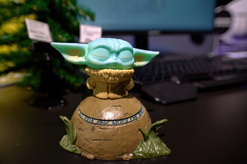 Naklejka premium Minsk, Belarus. Jan 12, 2025. Yoda figurine, the child or baby Yoda fictional character from the TV series The Mandalorian, green toy inspired by the famous sci-fi saga Star Wars. Selective focus