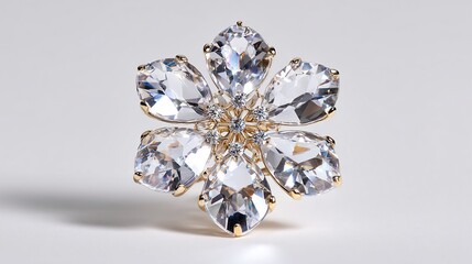 A gold-toned flower brooch, detailed with clear, faceted crystals