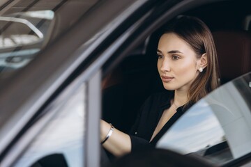 Woman test driving new luxury car at dealership