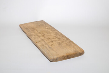 Close up of traditional coconut grater made of wood isolated on white background.Copy space for text.For graphic design,3D rendering and banners