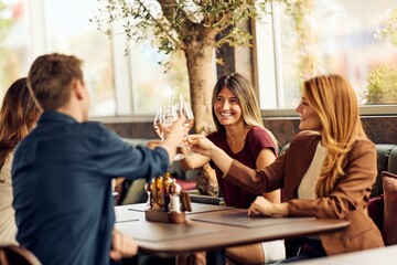 Group of Friends Toasting with Drinks at a Restaurant Table