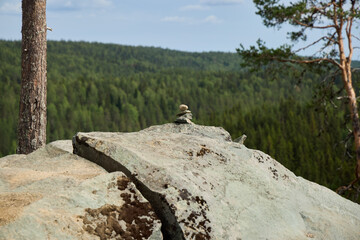 A Tranquil Nature Scene Featuring a Rocky Outcrop Surrounded by a Dense and Lush Forest
