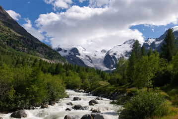 Morteratsch Glacier in Eastern Switzerland. Panoramic view of an alpine landscape with a glacier, river, lush green forests, and snow-capped mountains under a dynamic sky. Swiss Alps scenery.